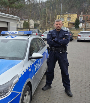 Policjant obok radiowozu