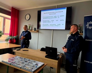 Dwójka policjantów podczas prelekcji w tle widoczna prezentacja Power Point