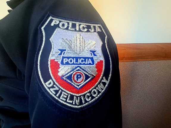 Zbliżenie rękawa bluzy policyjnej z napisem Policja