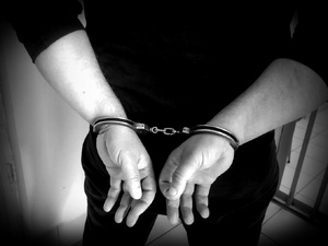 Zbliżenie rąk skutych kajdankami