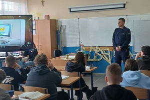 Policjant w sali szkolnej podczas pogadanki dla młodzieży