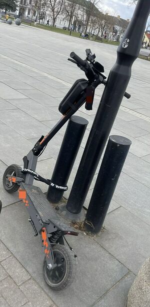 Hulajnoga przypięta do latarni na placu