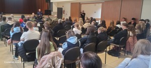 Dwaj policjanci prowadzący w sali kinowej prelekcję dla zgromadzonej młodzieży