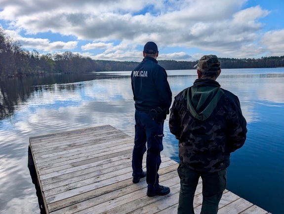 Policjant ze szpadlem i kobieta sadzący drzewko