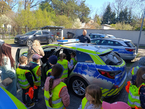 Na parkingu osiedlowym starszy mężczyzna, policjant i strażnik miejski