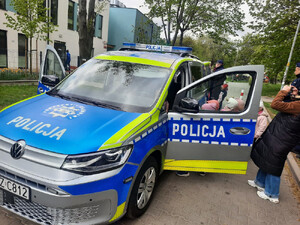 Grupa przedszkolaków oglądająca radiowóz typu SUV