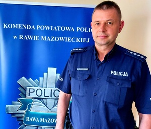 Policjant na tle wewnętrznego banneru jednostki