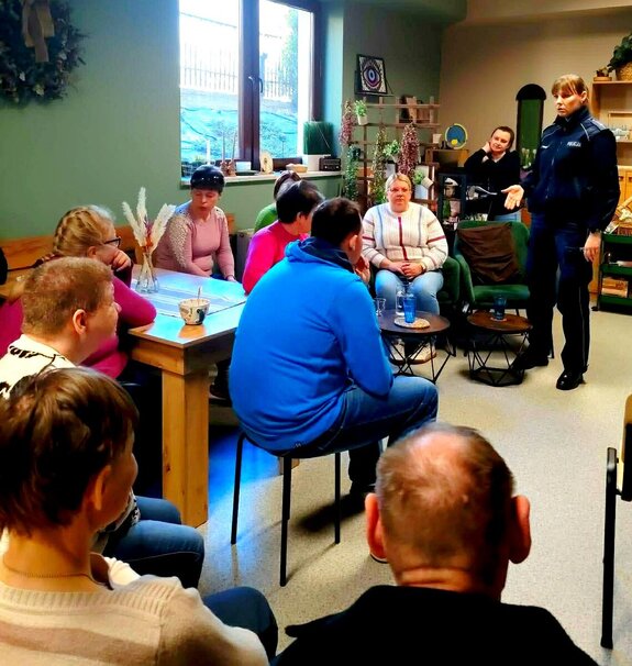 Policjantka w trakcie prelekcji w sali gdzie zgromadzone są osoby w rożnym wieku