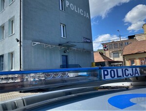 Zbliżenie dachu radiowozu z tzw. galeryjką na tle budynku Policji
