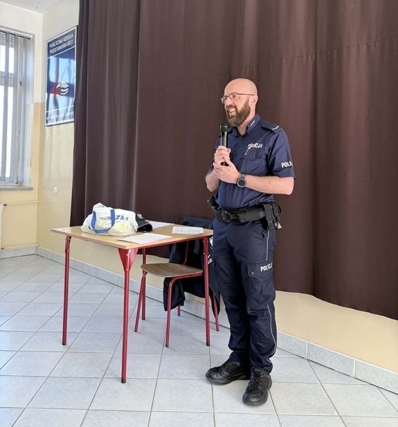 Policjant z mikrofonem w ręce podczas prelekcji