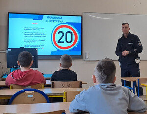 Policjant podczas pogadanki dla dzieci w sali szkolnej