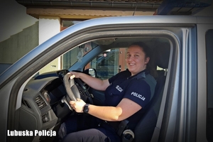 Uśmiechnięta policjantka za kierownicą radiowozu