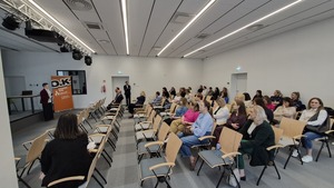 Sala wykładowa wypełniona osobami w różnym wieku