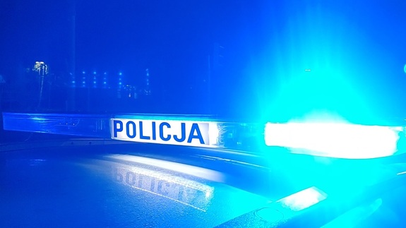 W scenerii nocnej dach radiowozu z włączoną tak zwaną galeryjką