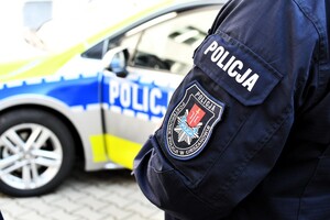 Rękaw bluzy policyjnej na tle radiowozu
