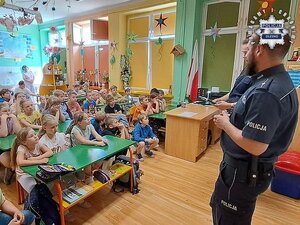 Policjanci w sali szkolnej prowadzący pogadankę dla dzieci