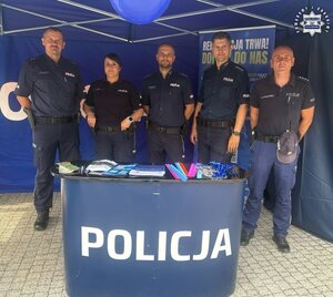 W namiocie wystawienniczym piątka policjantów pozująca do zdjęcia