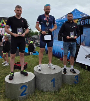 Trzech młodych mężczyzn ze statuetkami w rękach na podium