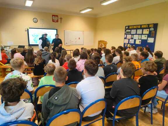 policjantka podczas prelekcji dla dzieci w klasie szkolnej
