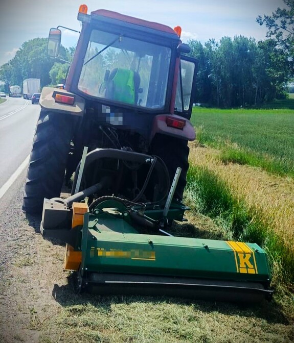 Ciągnik z kosiarką na poboczu drogi