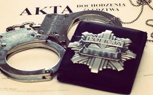 Zdjęcie kajdanek oraz legitymacji policyjnej w etui na okładkach dochodzenia.