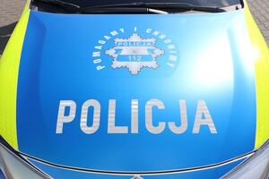biały napis POLICJA na niebieskiej masce samochodu