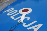 na niebieskiej masce radiowozu z białym napisem POLICJA ułożona jest tarcza do zatrzymywania pojazdów tzw. lizak