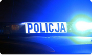 podświetlony napis Policja na dachu radiowozu z włączonymi światłami błyskowymi koloru niebieskiego