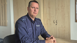 Policjant w średnim wieku siedzący przy biurku