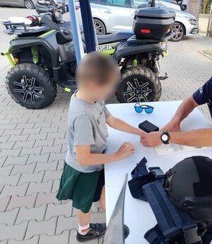 mały chłopiec z policjantem odciska linie papilarne na papierze