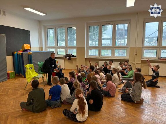Policjant z grupą dzieci w sali gimnastycznej